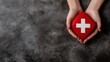 © Evon J - American Red Cross Month Caucasian female hands holding red first aid box on dark textured background