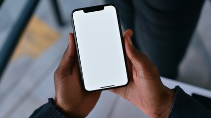 Close-up of hand holding smartphone with white blank screen, mockup technology concept.