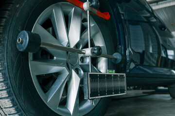 Aufkleber - Close-up of a car wheel being measured for alignment using professional calibration equipment in an auto workshop