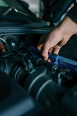 Aufkleber - A mechanic's hand replacing a car battery in the engine compartment of a modern vehicle during maintenance. Detailed view of car components and professional work