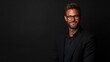 © Thinnawat - Confident Professional Man in Stylish Outfit with Glasses Posing Against Dark Background in Studio for Corporate and Modern Portrait Photography