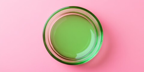 Poster - Isolated green circle glass lid on a pink background, creating a variety of abstract patterns that enhance the visual appeal of the green circle glass lid. Perfect for creative concepts.
