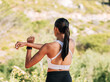 © Artem Varnitsin - Rear view of slim woman athlete warming up upper body and hands while standing outdoors in natural park