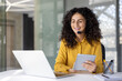© Liubomir - Woman with headset at workplace inside office holding tablet computer. Office worker of customer support and consulting service, inside office at workplace with laptop.
