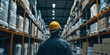 © meristock - A male employee works in a warehouse setting, specifically within the logistics industry, where he is engaged in tasks related to the storage and distribution of goods.
