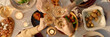 © AnnaStills - Website banner with top down shot of unrecognizable people clinking glasses with champagne above festive table served with delicious food