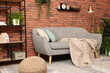 © New Africa - Modern living room interior. Comfortable sofa near brick wall