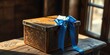 © BokehBox - A beautifully crafted wooden box adorned with intricate carvings, tied with a vibrant blue ribbon, rests upon a weathered wooden surface, capturing the essence of a timeless gift