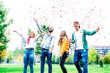 © charmedlightph - Happy smiling young people jumping throwing colors confetti outdoor at park - Young students laughing and celebrating together - Lifestyle concept with young friends having fun together after school