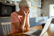 © Marko Geber - Senior woman working on laptop at home