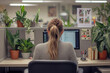 © ivlianna - Young woman personalizing her cubicle with plants and decorations in a modern office environment