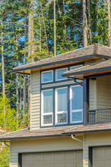 Wall Mural - Top of grey stucco luxury house with shingle roof, red and yellow trees and nice windows in Spring in Vancouver, Canada, North America.