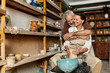 © LIGHTFIELD STUDIOS - A beautiful couple shapes clay in a pottery class, sharing love and creativity in the moment.