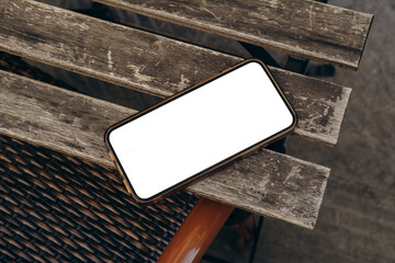 Mockup woman's hand holding using smart phone with white blank screen at coffee shop, mobile app design and advertising, online marketing