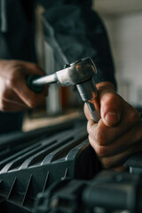 Aufkleber - Mechanic tightening a bolt on a car engine using a ratchet wrench in a professional workshop setting