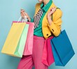 © Niko - A stylish young woman laughing while carrying vibrant shopping bags