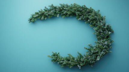 Poster - Christmas wreath on turquoise background with copy space for text. Round decorative arrangement of evergreen branches and foliage.