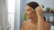 © Krakenimages.com - Woman enjoying a relaxing facial massage with a jade roller in a wellness spa room.