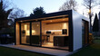 © Pierre Villecourt - Petite maison moderne préfabriquée avec grandes baies vitrées, cuisine intérieure élégante et barbecue extérieur au crépuscule