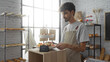 © Krakenimages.com - Young hispanic man with beard working in a bakery arranging gluten-free pastries in a tray with baked goods in the background in a bright indoor setting