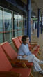 © Krakenimages.com - Woman sitting on a cruise dock outdoors smiling with her phone embracing the sea breeze in a relaxed and stylish manner.