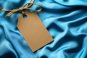 Wall Mural - Blank Kraft Tag on Blue Silk Fabric