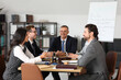 © Pixel-Shot - Group of lawyers working at table in office