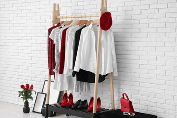 Wall Mural - Rack with clothes and accessories near white brick wall in dressing room