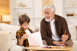 © New Africa - Grandpa and his grandson drawing at table indoors
