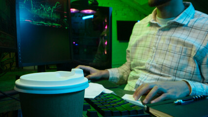 Pensive Caucasian man professional software engineer guy male coder programmer crypto specialist drinking coffee workplace looking computer thinking pondering creating innovative digital application
