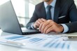 © STwul - Businessman analyzing data on laptop in modern office (1)