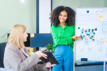 a young african american woman and a young russian woman work together in a business office. they di