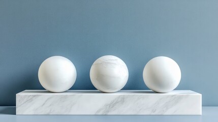 Poster - Three white marble spheres on a marble base against a blue background.