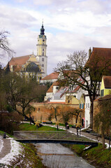 Wall Mural - Tall church spire in a medieval town in southern Germany with the Danube River in the foreground