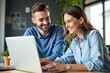 © SimpleDesignStudio - Joyful young couple collaborating on a modern laptop in a cozy home office space, showcasing teamwork and digital communication skills