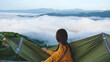 © Farknot Architect - Rear view of a woman sitting on hammock and looking at a mountain view and sea of fog