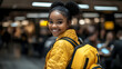 © Siasart Stock - Young Traveler Smiles Brightly at Airport Terminal with Yellow Backpack