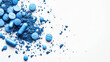 © Tatsiana - Blue powder and tablets scattered on a white surface inviting creativity and inspiration for wellness and health initiatives