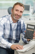 © auremar - a happy businessma is showing calculator