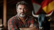 © Freshpixel - A serious-faced man stands strong beside a bull in a barn adorned with flags, embodying the pride and tradition of rural community life.