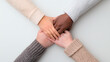 © El So - Hands of diverse individuals holding together in a circle on a clean white background, symbolizing unity and support.