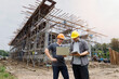 © skarie - Engineers inspecting construction progress at a building site using digital devices. Collaboration and technology driving modern infrastructure development.