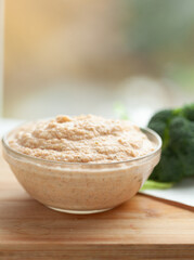 Wall Mural - Creamy dip in a glass bowl, served alongside fresh broccoli. Perfect for a healthy and delicious snack or appetizer.