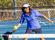 © Jo - Female pickelball player stretches to hit a forehand volley