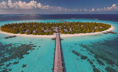 Fototapete - A beautiful island with a wooden bridge connecting it to the mainland. The island is surrounded by water and has palm trees
