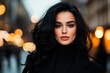 © michnik101 - Portrait of a woman with flowing dark hair wearing a black outfit on a city street with glowing evening lights. Elegance and allure