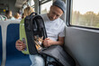 © DimaBerlin - Man owner checks cat comfort in travel friendly pet backpack on train journey. Guy looking at stressed animal in portable carrier, animal care, domestic animal travel, mobile convenience for trips