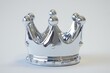 © Fotograf - A single silver crown resting on a clean white surface