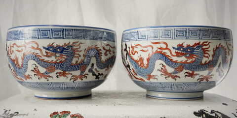 Pair of antique porcelain bowls with dragon motif.  Intricate blue and red design.