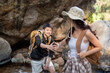 © Natee Meepian - LGBT couple playfully reaching out to each other during their hiking adventure